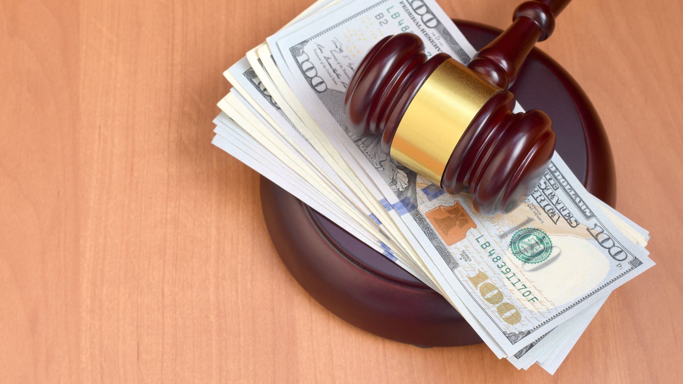 A gavel resting on a stack of US dollar bills, symbolizing the financial resolutions in Texas personal injury cases. This image highlights how personal injury settlements are paid out in Texas, reflecting the crucial legal processes involved in compensating injury victims.