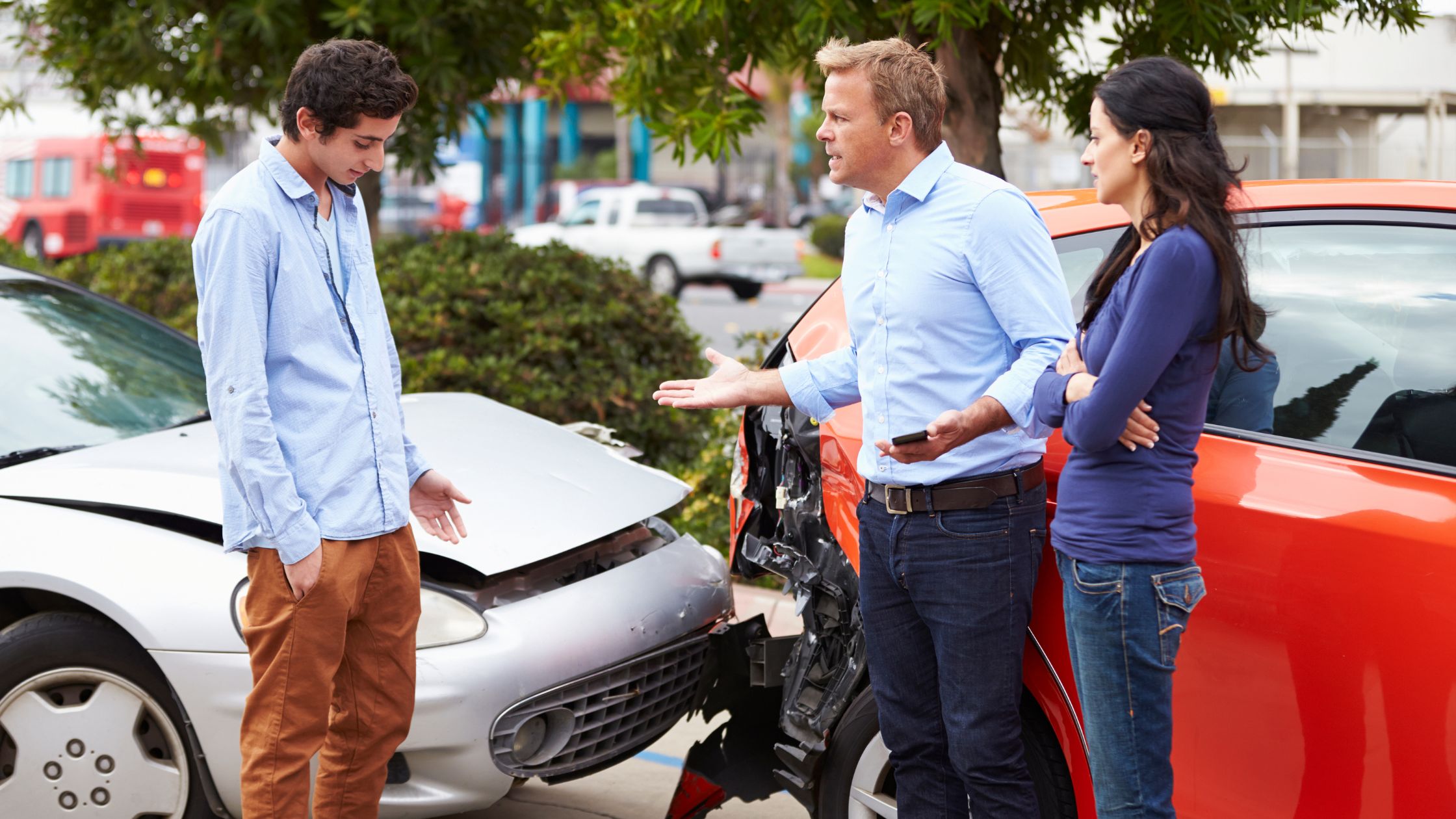 Group of individuals discussing a car accident scene in Texas, highlighting the complexities of fault in such incidents. This image relates to the blog post titled 'What Happens If I Share Fault For a Car Crash in Texas?' and emphasizes the importance of understanding shared fault in auto accidents.